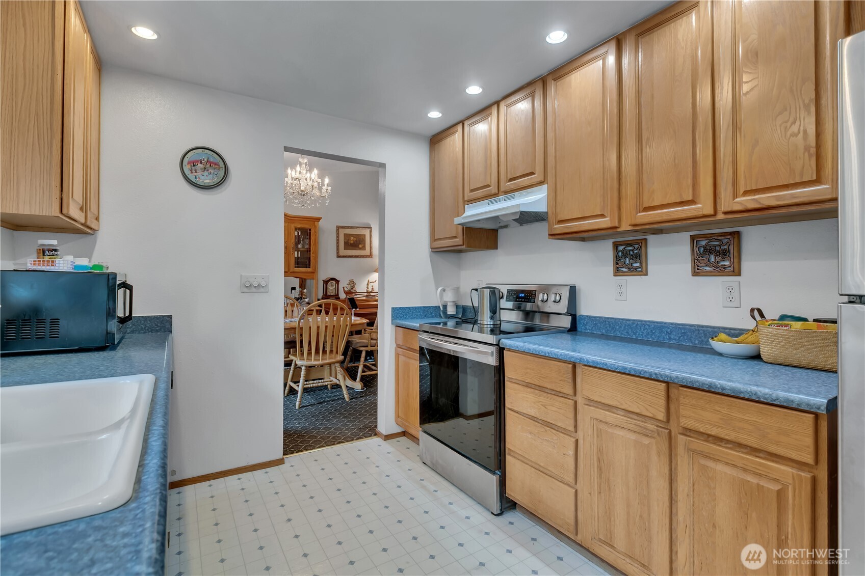 7316 Eustis Hunt Road Spanaway, WA 98387 - Photo 9 of 32 a kitchen with stainless steel appliances granite countertop a refrigerator sink and cabinets