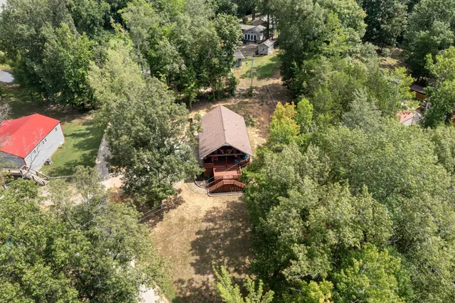 a aerial view of a house with a yard and large trees