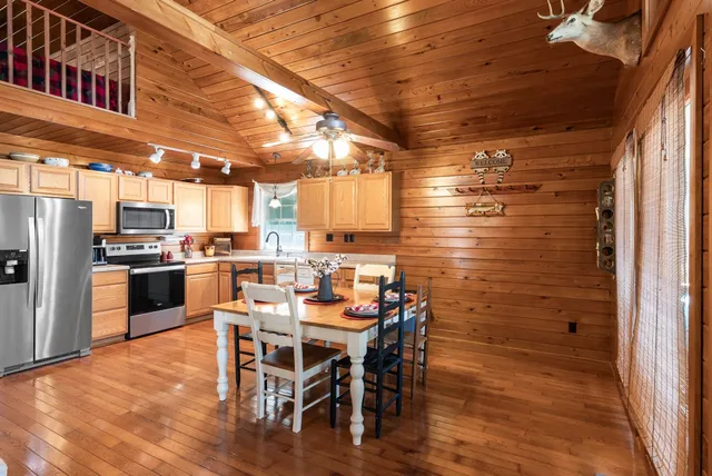 a kitchen with a table chairs refrigerator and cabinets