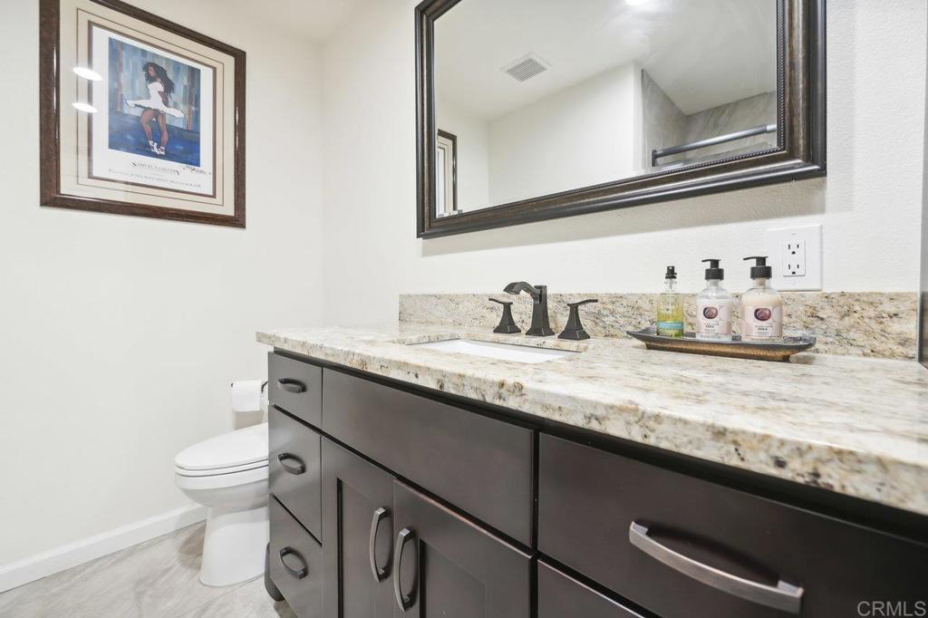 430 Silver Shadow Drive San Marcos, CA 92078 - Photo 26 of 36 a bathroom with a granite countertop sink a toilet and a mirror