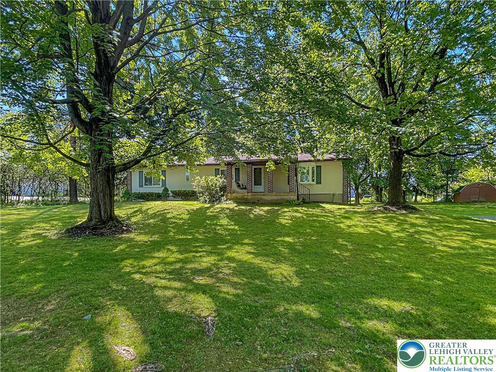 3406 Church Road Easton, PA 18045 - Photo 1 of 39 A classic ranch home nestled amidst verdant trees offers a spacious, welcoming lawn.