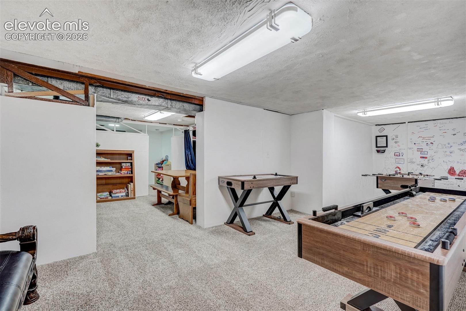9955 Mesa Road Cascade, CO 80809 - Photo 35 of 41 Carpeted recreation room with exposed ceiling beams and recessed lighting