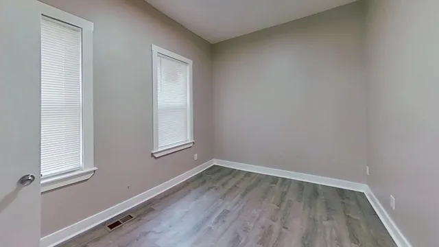 a view of a small space with wooden floor and a window