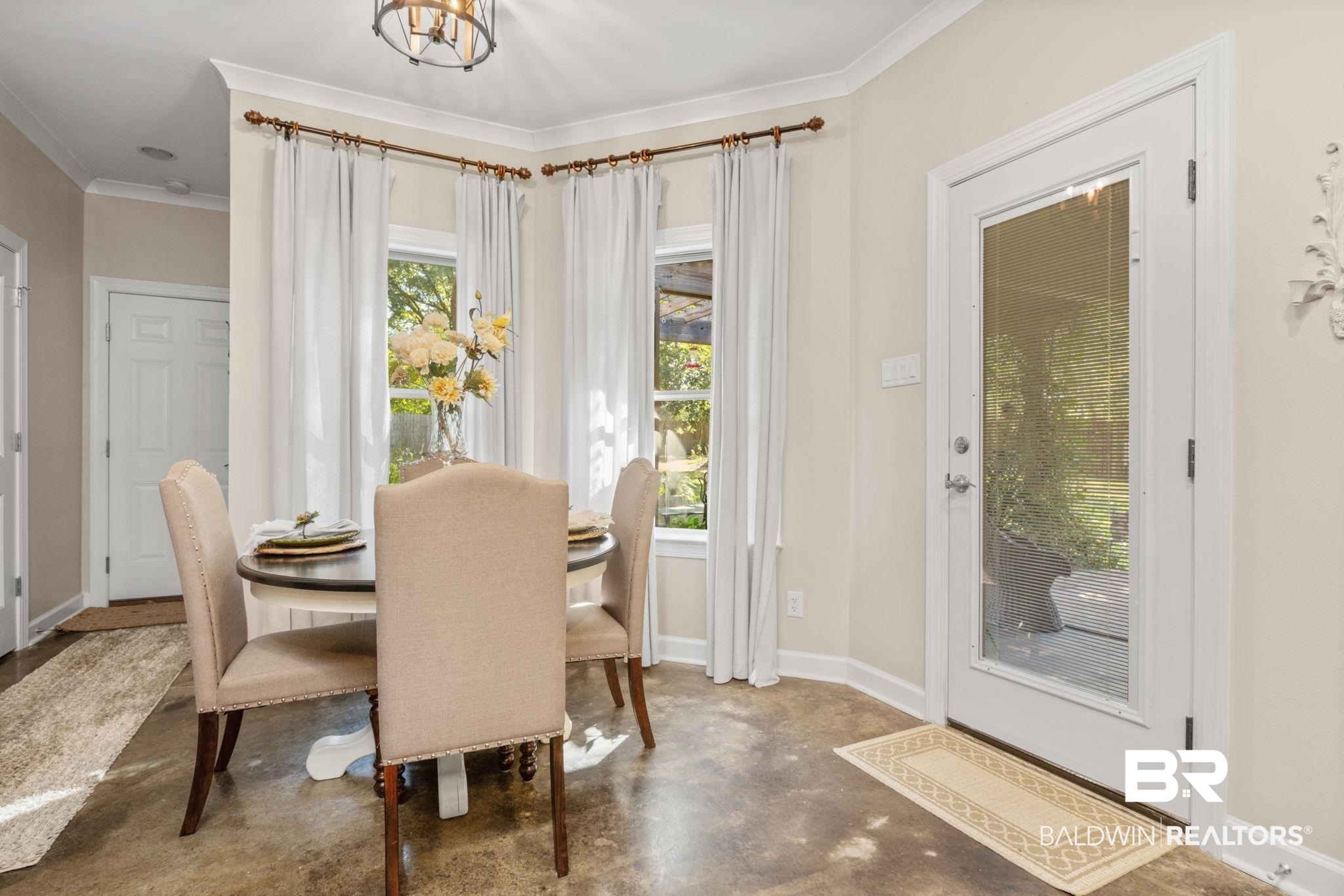 4331 Hamilton Oaks Lane Mobile, AL 36695 - Photo 11 of 38 Dining space featuring finished concrete floors, ornamental molding, baseboards, and a chandelier