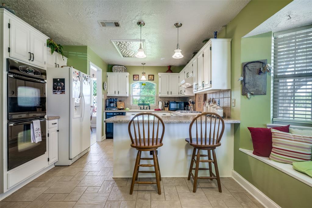 1 Finley Circle Krum, TX 76249 - Photo 11 of 30 a kitchen with stainless steel appliances granite countertop a kitchen island a table and chairs