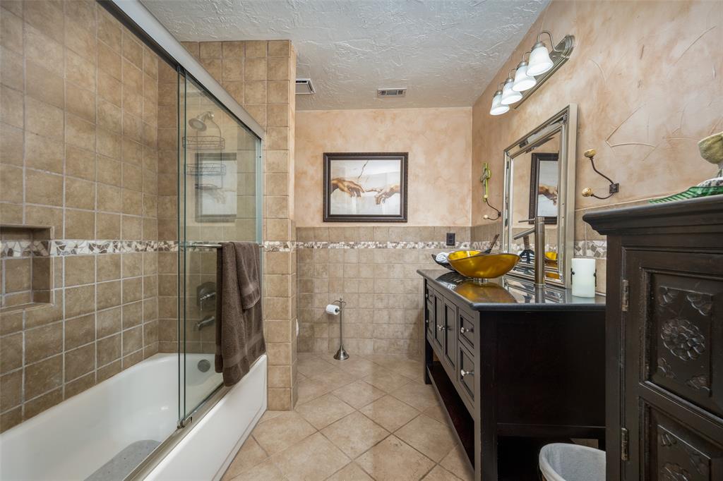1 Finley Circle Krum, TX 76249 - Photo 19 of 30 a spacious bathroom with a granite countertop sink a mirror a bathtub and a shower