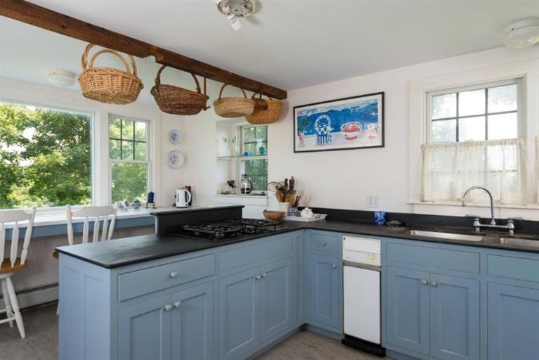 24 Champlain Road Chatham, MA 02633 - Photo 5 of 26 a kitchen with a large window cabinets a sink and a window