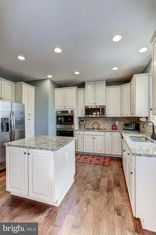 a kitchen with stainless steel appliances granite countertop a stove sink and cabinets