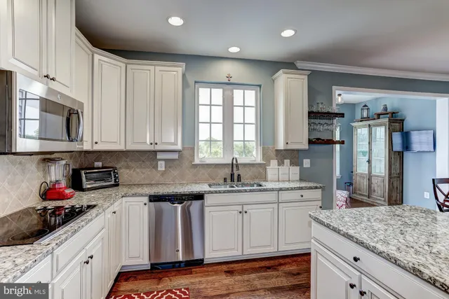 a kitchen with stainless steel appliances granite countertop a sink stove and cabinets