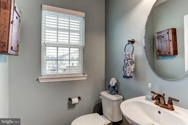 a bathroom with a toilet a sink and mirror