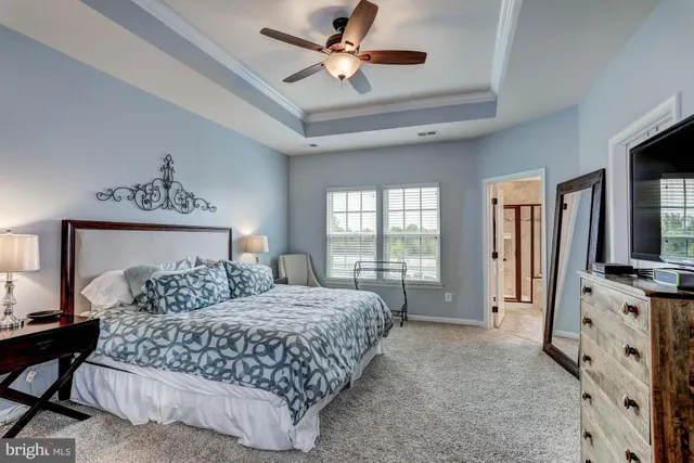 a bedroom with a bed a window and a chandelier