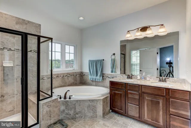 a bathroom with a tub sink and mirror