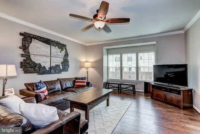 a living room with furniture a flat screen tv and a window