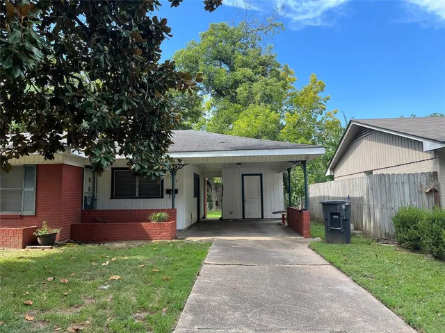 a front view of a house with a yard and potted plants