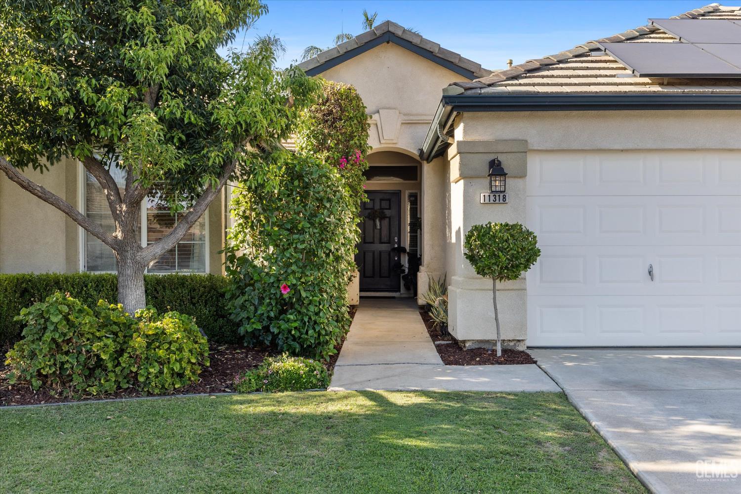 Undisclosed Address Bakersfield, CA 93312 - Photo 11 of 61 a view of a house with a yard and plants