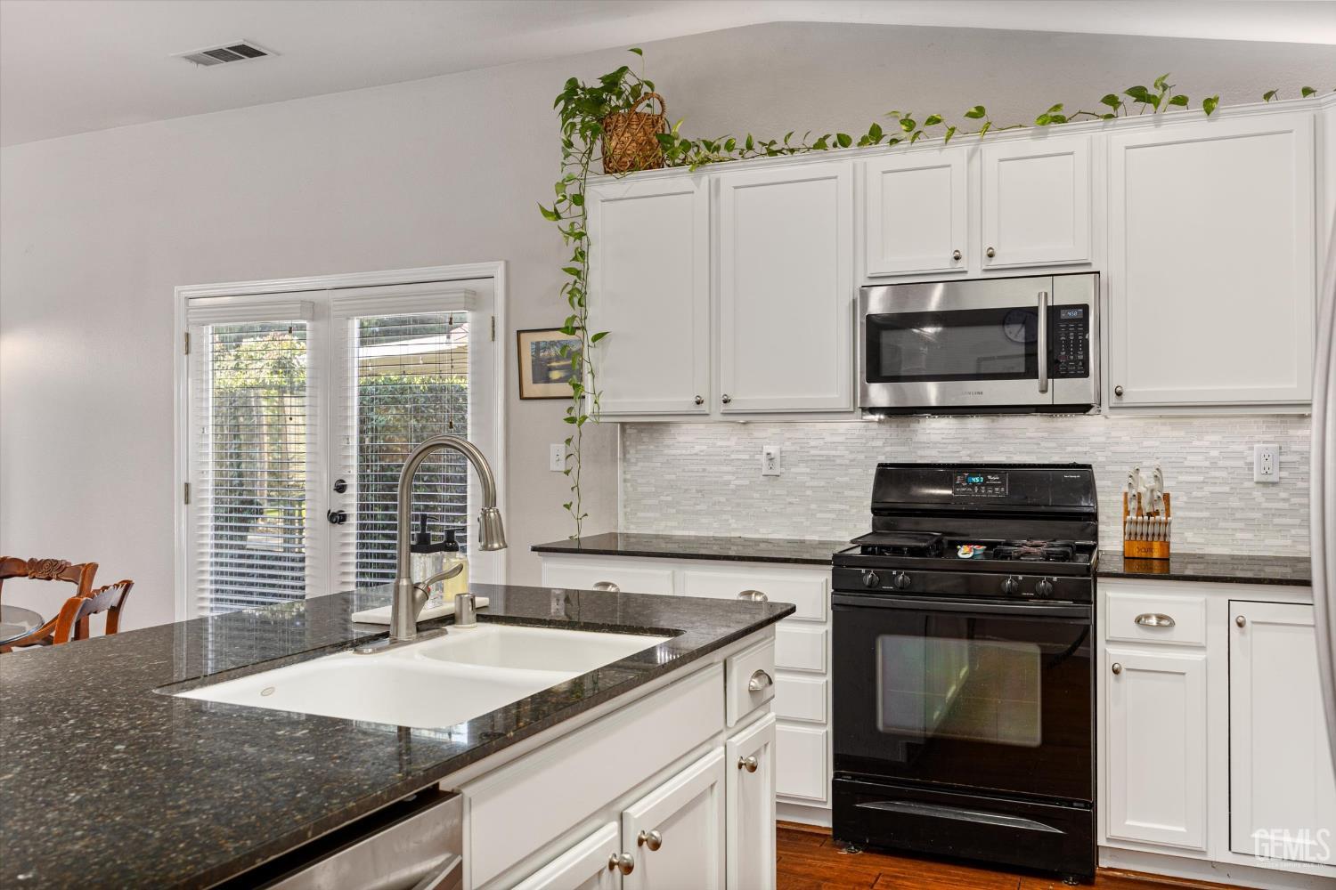 Undisclosed Address Bakersfield, CA 93312 - Photo 32 of 61 a kitchen with granite countertop a sink a stove and cabinets