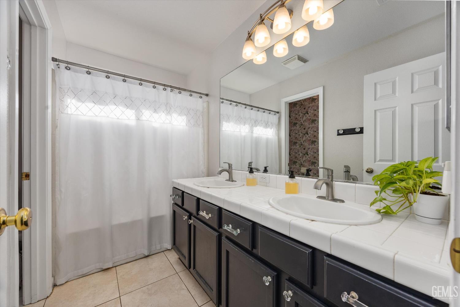 Undisclosed Address Bakersfield, CA 93312 - Photo 42 of 61 a bathroom with a double vanity sink and a mirror