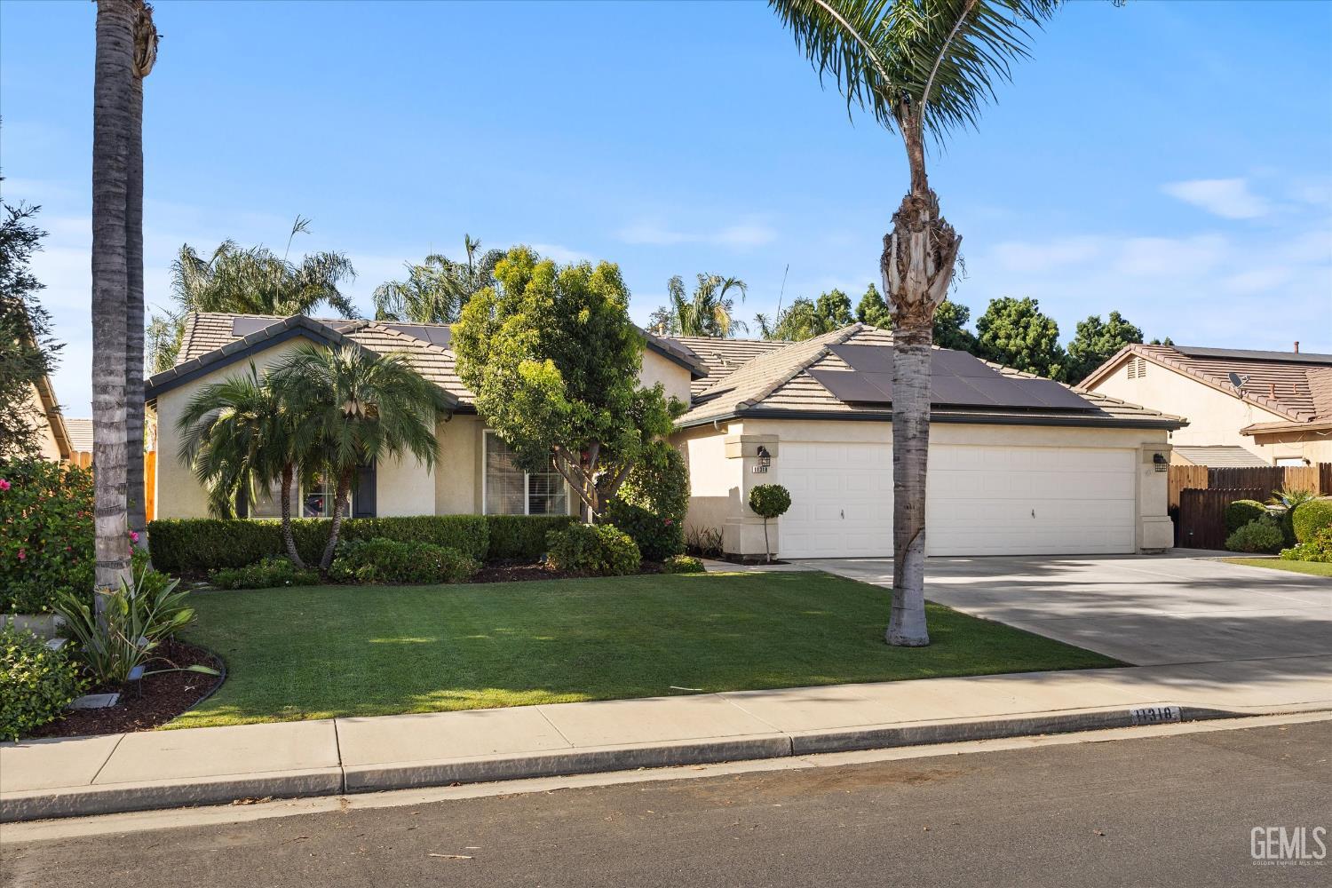 Undisclosed Address Bakersfield, CA 93312 - Photo 10 of 61 a front view of a house with a garden and a yard