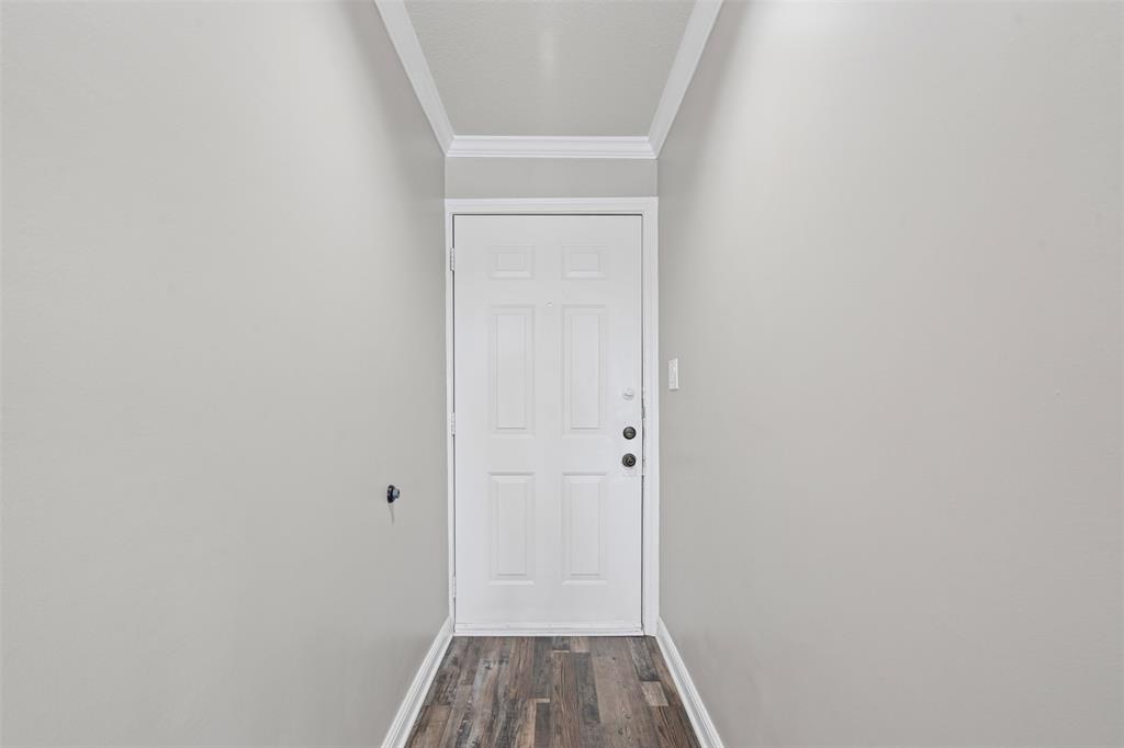 401 East Pearl Street, Unit 2306 Granbury, TX 76048 - Photo 7 of 17 Front doorway withmolding, baseboards, and dark wood-style floors