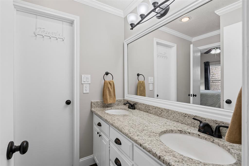 401 East Pearl Street, Unit 2306 Granbury, TX 76048 - Photo 9 of 17 Primary Bathroom featuring a sink, double granite vanity, and crown molding