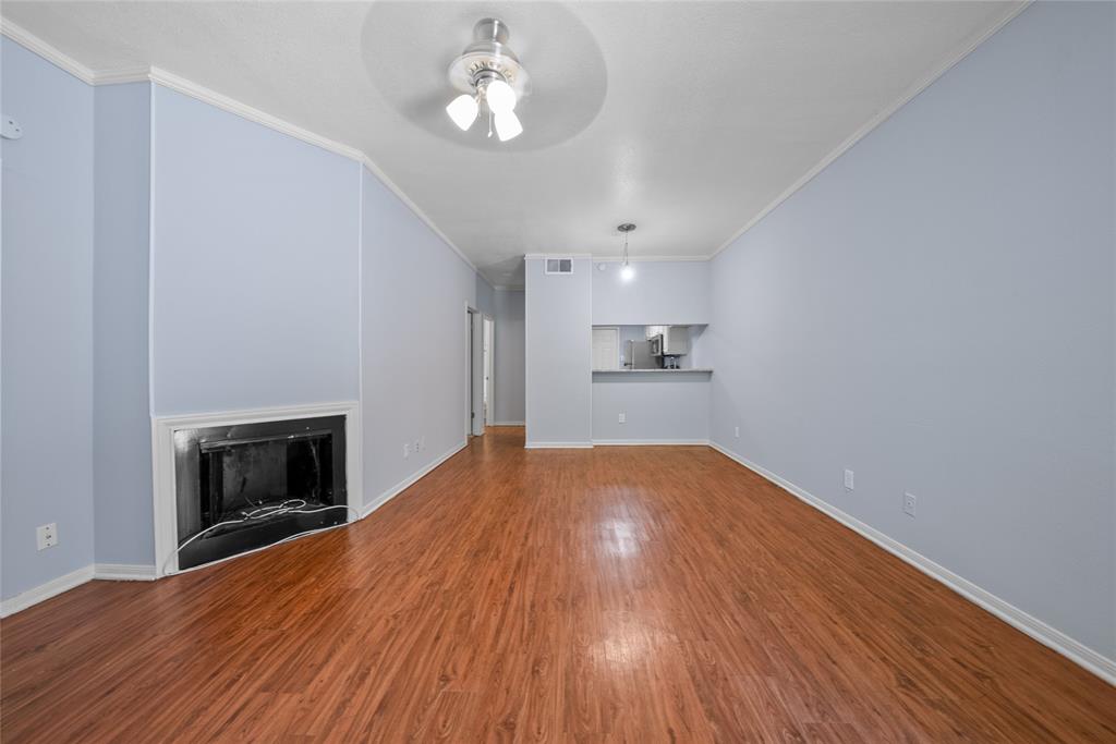8545 Midpark Road, Unit 47 Dallas, TX 75240 - Photo 2 of 10 a view of empty room with wooden floor and fireplace