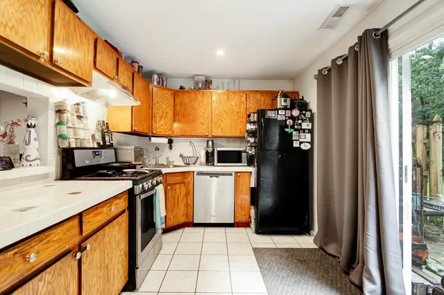 a kitchen with stainless steel appliances granite countertop a refrigerator and a stove