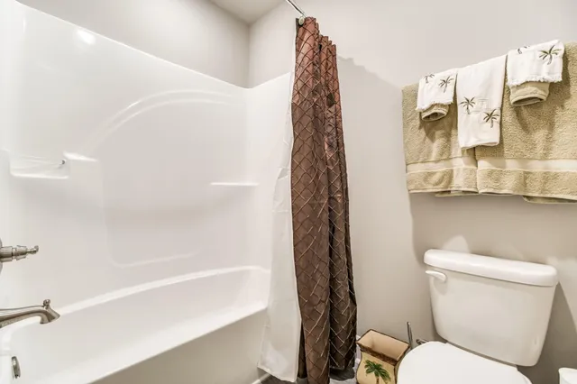 a bedroom with a bed and a ceiling fan