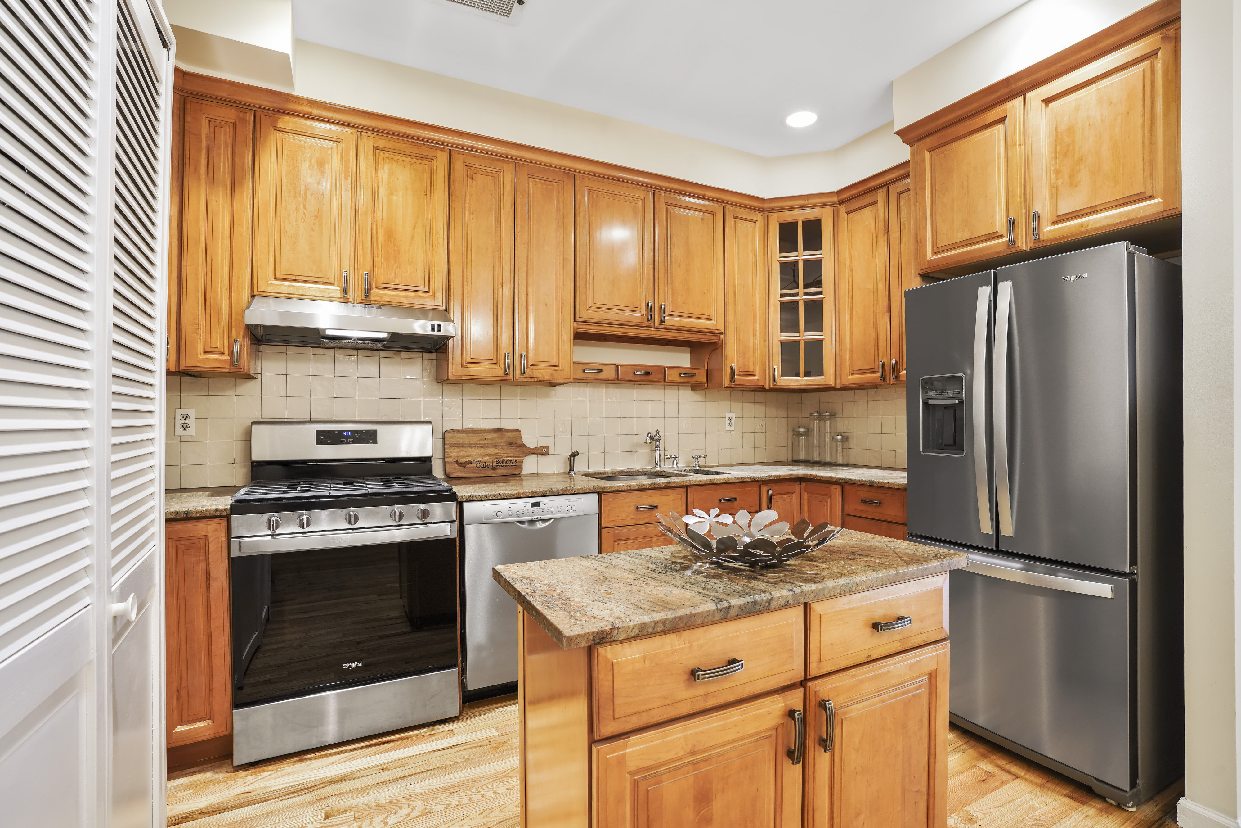a kitchen with granite countertop a refrigerator stove top oven and cabinets