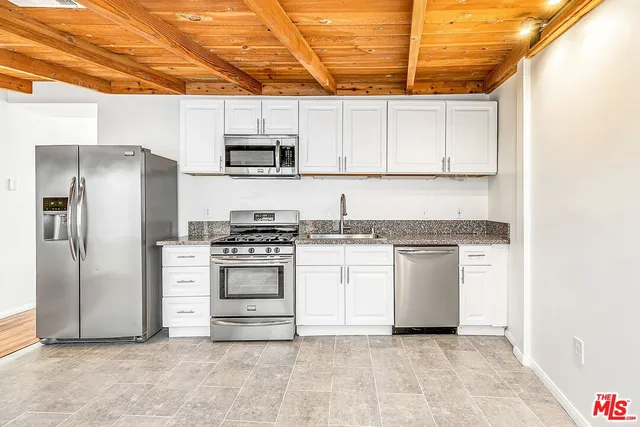 a kitchen with stainless steel appliances granite countertop a refrigerator and a stove