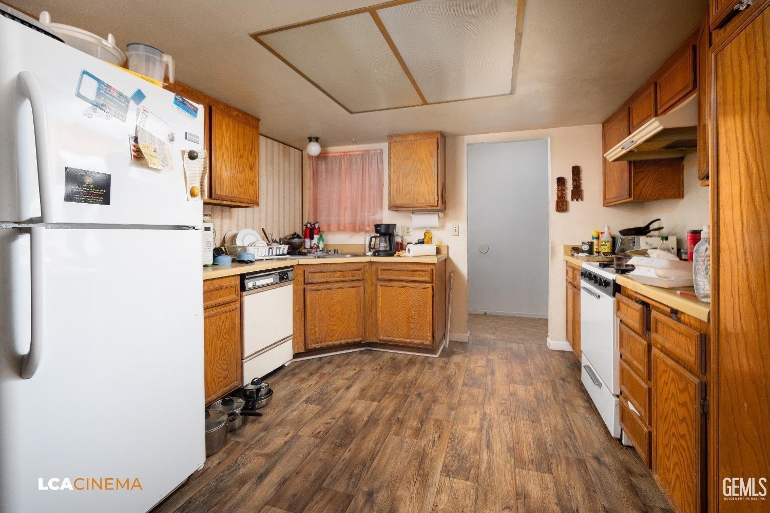 Undisclosed Address Bakersfield, CA 93304 - Photo 6 of 15 a kitchen with cabinets wooden floor and stainless steel appliances