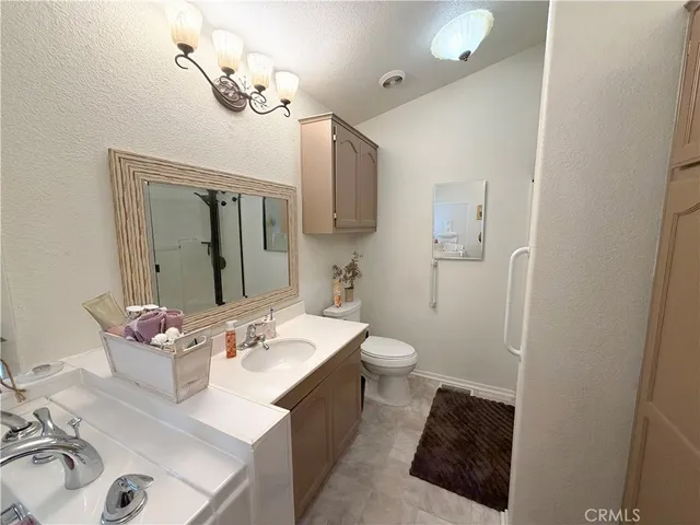 a bathroom with a sink vanity granite and toilet