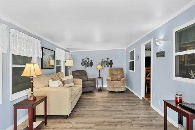 a living room with furniture large mirror and wooden floor