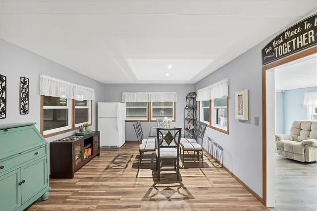 a living room with furniture a rug kitchen view and a large window