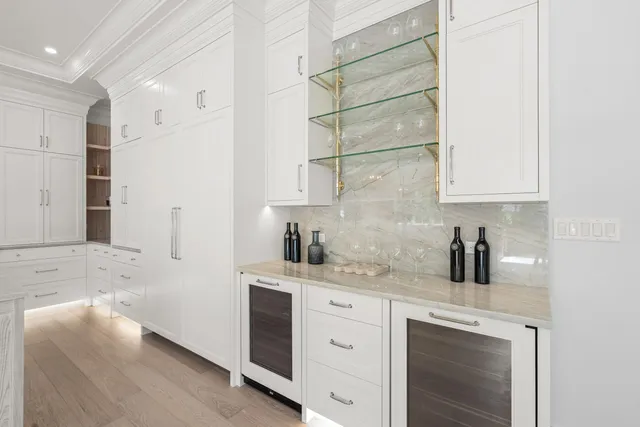 a kitchen with a sink dishwasher and white cabinets with wooden floor