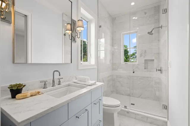 a bathroom with a sink a toilet and shower