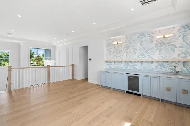 a view of a kitchen with a sink and dishwasher a stove top oven with wooden floor