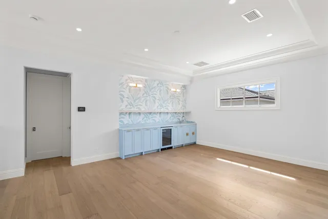an empty room with a kitchen and a sink