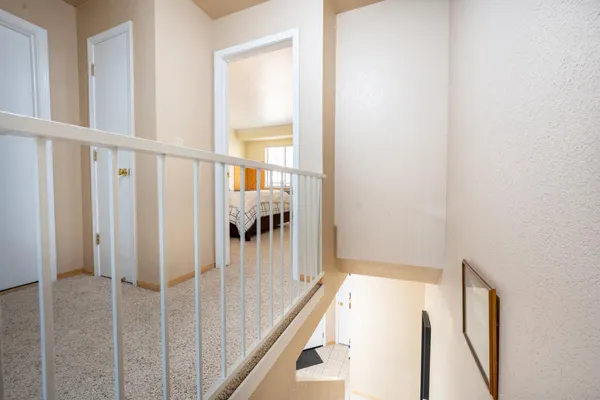 a view of a hallway with wooden floor and staircase