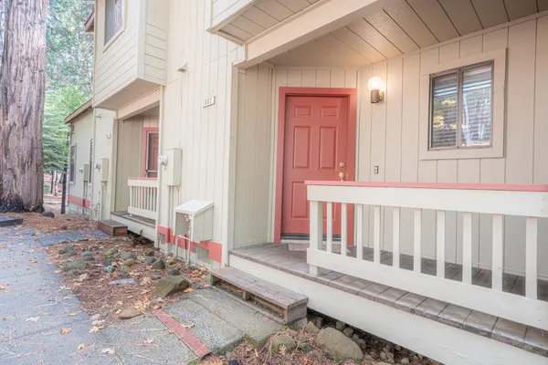 a view of a house with a small yard and wooden floor and fence