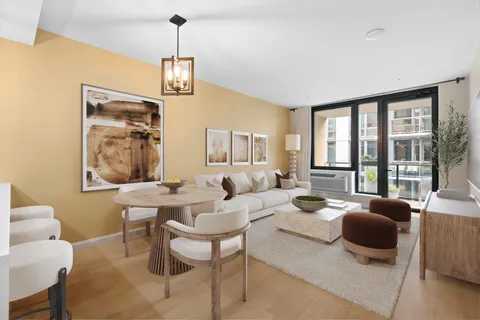 a living room with furniture a flat screen tv and a window