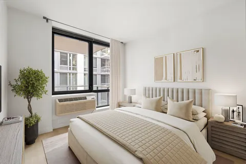 a bedroom with a bed and a large window