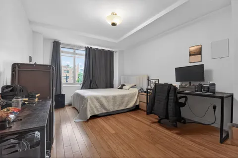 a bedroom with a bed and wooden floor