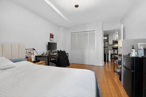 a bedroom with bed and wooden floor