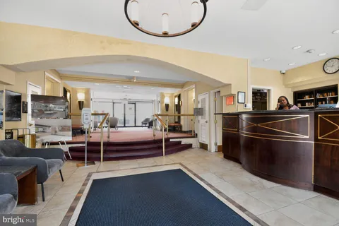 a living room with furniture a rug and kitchen view