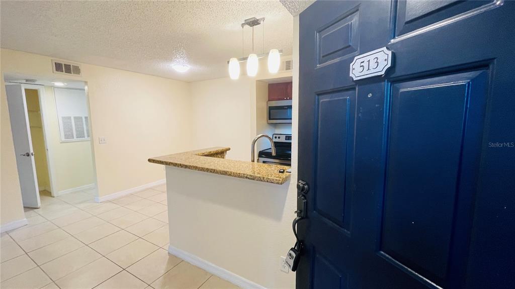 5120 Conroy Road, Unit 13 Orlando, FL 32811 - Photo 10 of 25 a kitchen with granite countertop a sink and a refrigerator