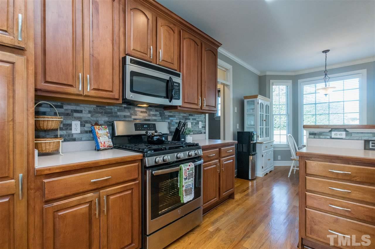 1000 Nortonbridge Road Raleigh, NC 27603 - Photo 3 of 30 a kitchen with stainless steel appliances granite countertop a stove a sink and a microwave