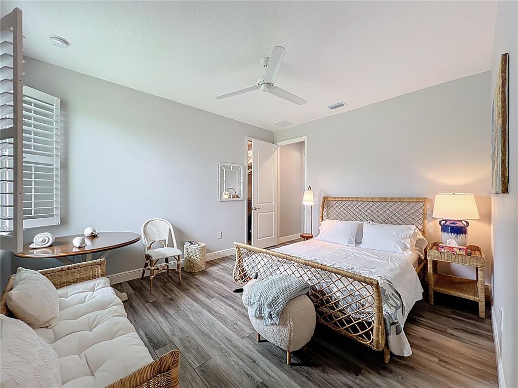 10220 Bay Lake Road Groveland, FL 34736 - Photo 27 of 67 a bedroom with a bed and wooden floor