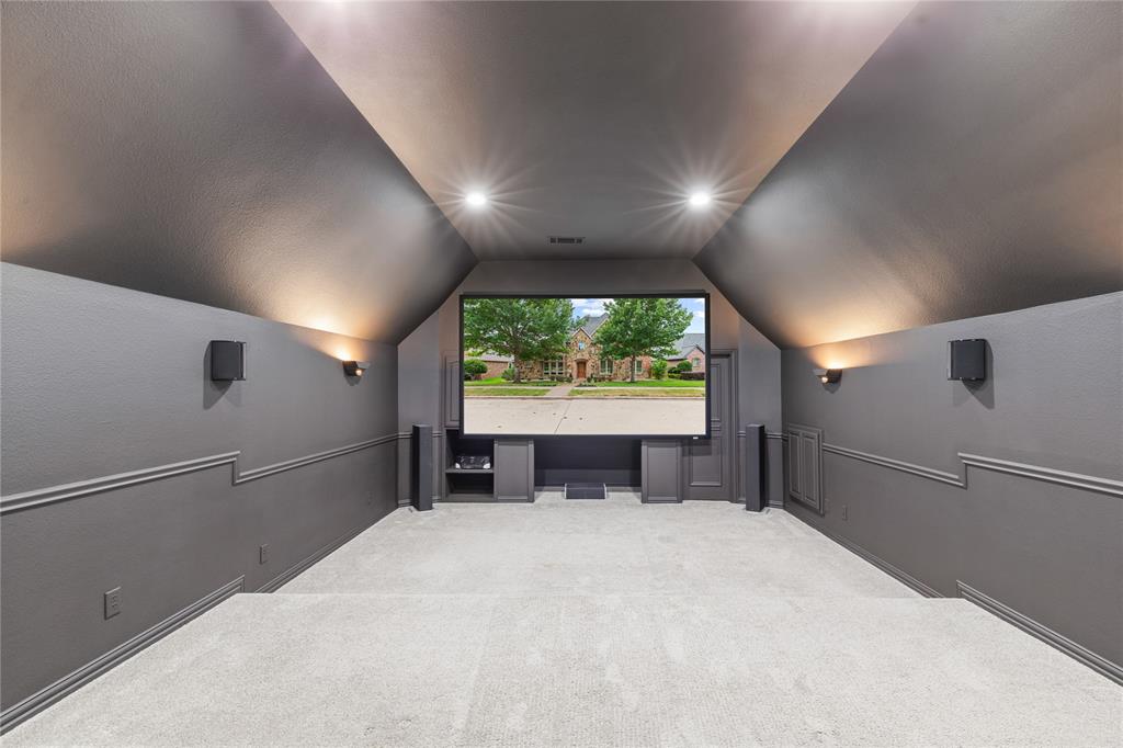 967 East Bethel School Road Coppell, TX 75019 - Photo 2 of 39 Dedicated media room featuring a large projection screen, integrated speakers, recessed lighting, and sconce lighting