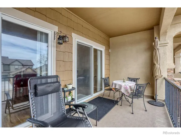 a balcony with table and chairs
