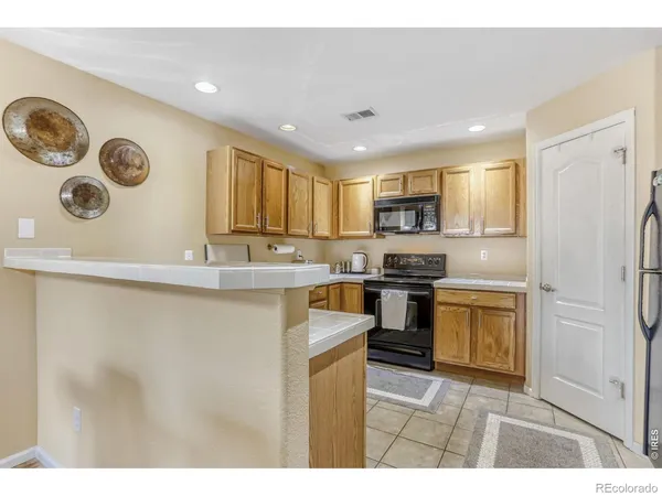 a kitchen with a refrigerator and a stove top oven